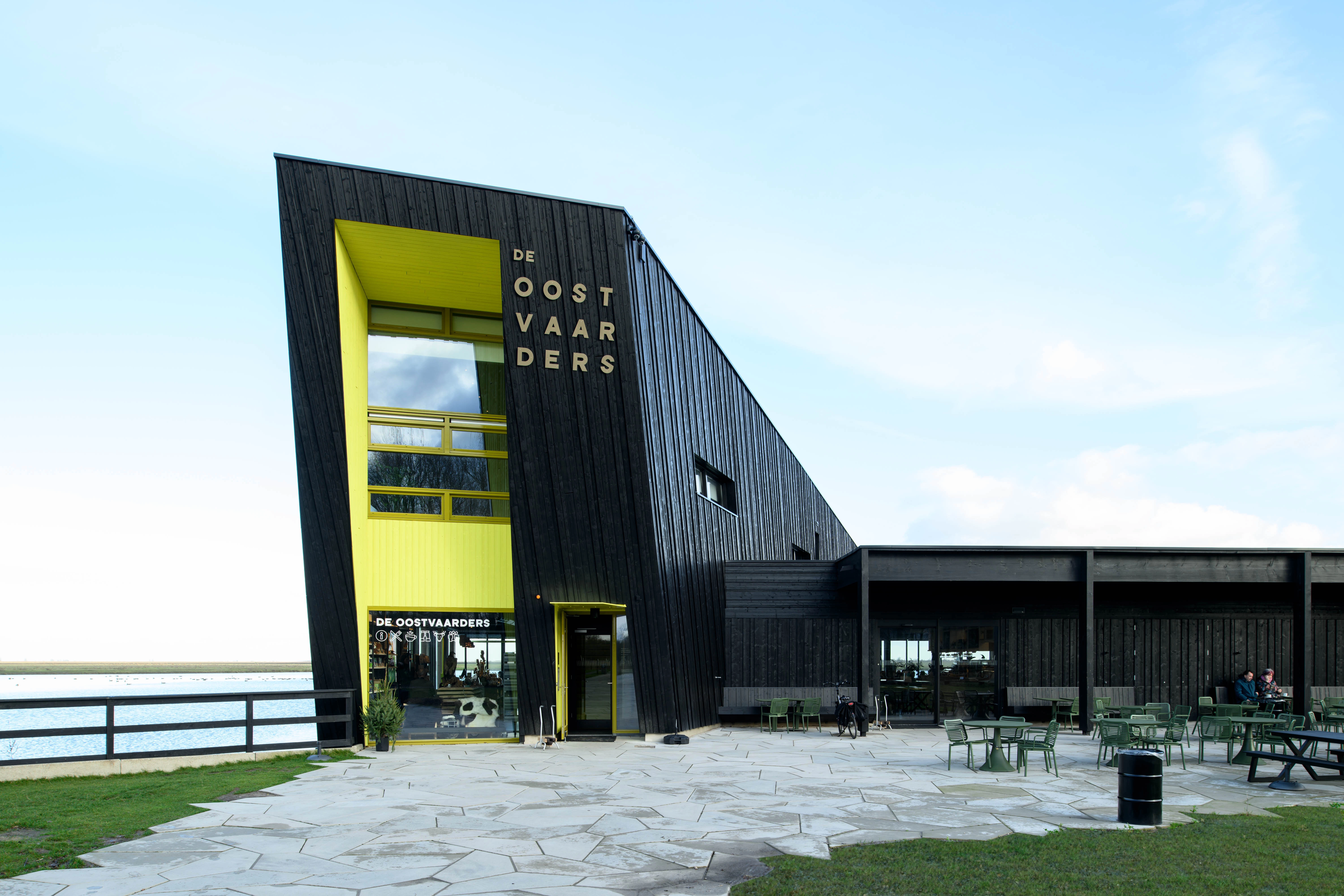 Exterieur van modern gebouw “de Oostvaarders” met uitzicht op water, entree van het natuurbelevingscentrum en expo.