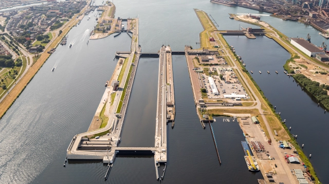 Luchtfoto van Zeesluis IJmuiden met sluizencomplex, waterwegen, industrieterrein en omliggende infrastructuur richting Noordzee.