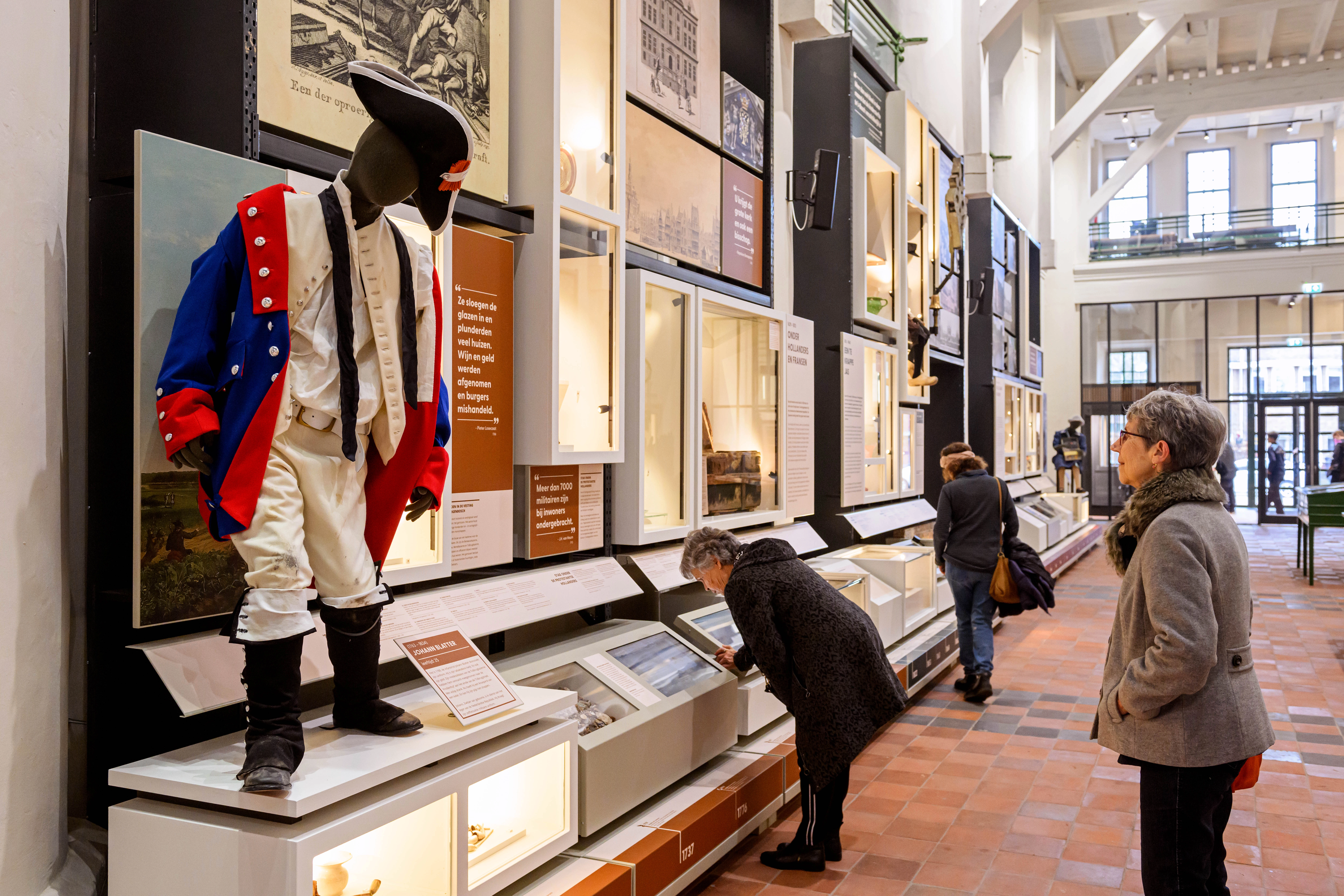 Bezoekers kijken naar de wand van de expositie