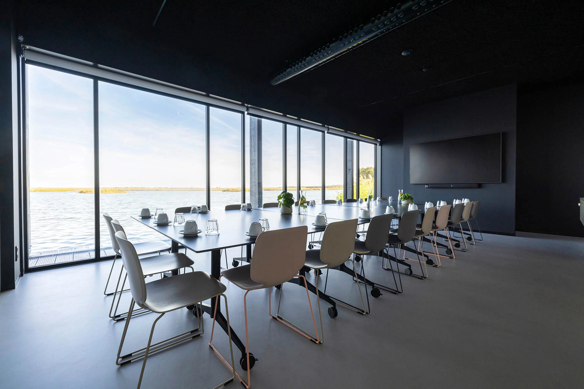 Vergaderruimte met een lange tafel en stoelen eromheen